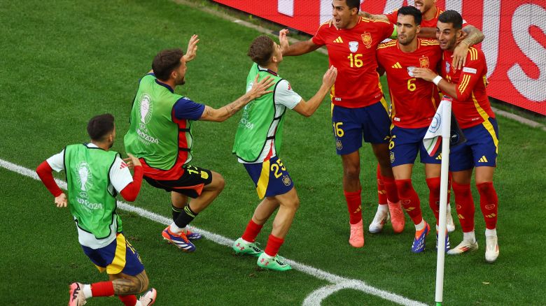Spain's Mikel Merino celebrates with teammates after scoring the quarterfinal winner against Germany.