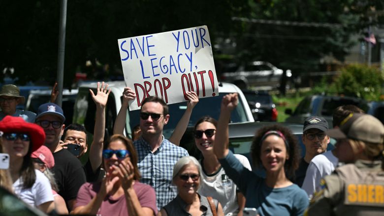 A person holds up a sign encouraging President Joe Biden to drop out of the 2024 presidential race as Biden's motorcade arrives at a campaign rally at Sherman Middle School in Madison, Wisconsin, on July 5.