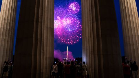 WASHINGTON, DC - JULY 04: Spectators watch as fireworks erupt over the Washington Monument on July 4, 2022 in Washington, DC. Crowds lined the National Mall to watch the capitals annual fireworks show celebrating Independence Day. (Photo by Nathan Howard/Getty Images)